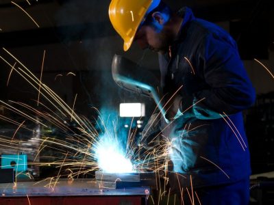 14287476 - worker making sparks while welding steel isolated